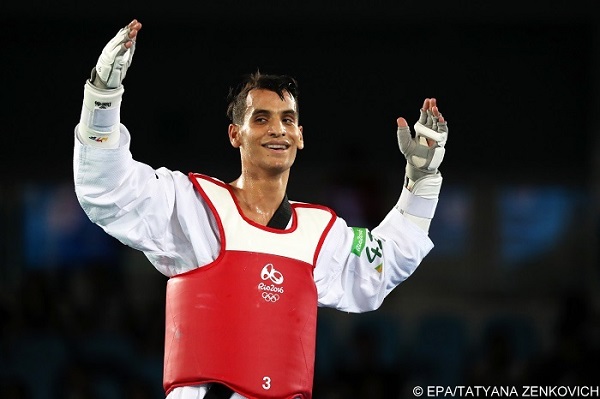 epa05498131 Ahmad Abughaush of Jordan (red) celebrates defeating Alexey Denisenko of Russia (blue) during the men's -68kg Gold Medal contest bout of the Rio 2016 Olympic Games Taekwondo events at the Carioca Arena 3 in the Olympic Park in Rio de Janeiro, Brazil, 18 August 2016.  EPA/TATYANA ZENKOVICH