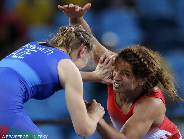 epa05494142 Marwa Amri (red) of Tunisia in action against Yuliya Ratkevich (blue) of Azerbaijan during the women's Freestyle 58kg bronze medal game of the Rio 2016 Olympic Games Wrestling events at the Carioca Arena 2 in the Olympic Park in Rio de Janeiro, Brazil, 17 August 2016.  EPA/SERGEI ILNITSKY