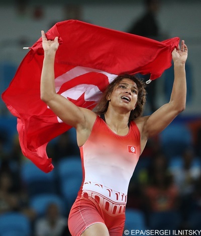 epa05494147 Marwa Amri of Tunisia celebrates after defeating Yuliya Ratkevich of Azerbaijan to win bronze in the women's 58kg category of the Rio 2016 Olympic Games Wrestling events at the Riocentro in Rio de Janeiro, Brazil, 17 August 2016.  EPA/SERGEI ILNITSKY