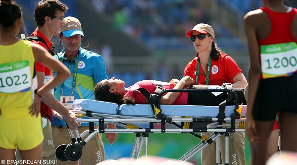 epa05492760 Fatma El Sharnouby (C) of Egypt is stretchered off the track during the women's 800m heats of the Rio 2016 Olympic Games Athletics, Track and Field events at the Olympic Stadium in Rio de Janeiro, Brazil, 17 August 2016.  EPA/SRDJAN SUKI