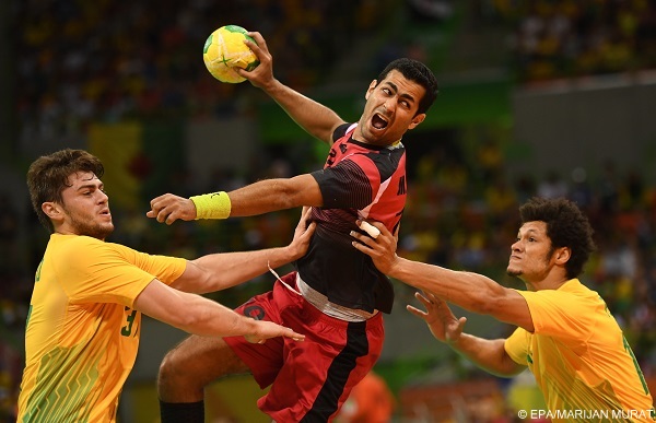 epaselect epa05481258 Egypt's Mohamed Elbassiouny (C) in action with Brazil's Haniel Langaro (L) and Thiagus Dos Santos (R) during the men's preliminary round match between Egypt and Brazil for the Rio 2016 Olympic Games Handball tournament at the Future Arena in the Olympic Park in Rio de Janeiro, Brazil, 13 August 2016.  EPA/MARIJAN MURAT