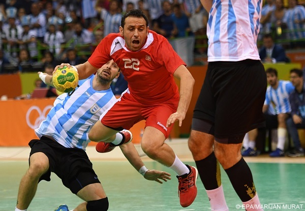 epa05482701 Tunisia's Sobhi Saied (C) in action with Argentina's Pablo Portela (L) during the men's preliminary round match between Argentina and Tunisia for the Rio 2016 Olympic Games Handball tournament at the Future Arena in the Olympic Park in Rio de Janeiro, Brazil, 13 August 2016.  EPA/MARIJAN MURAT
