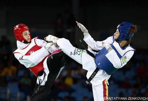 epa05497364 Eva Calvo Gomez of Spain (blue) and Hedaya Wahba of Egypt (red) in action a women's -57kg semi finals bout of the Rio 2016 Olympic Games Taekwondo events at the Carioca Arena 3 in the Olympic Park in Rio de Janeiro, Brazil, 18 August 2016.  EPA/TATYANA ZENKOVICH