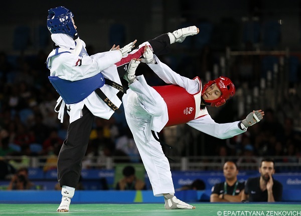 epa05497858 Hedaya Wahba of Egypt (blue) and Raheleh Asemani of Belgium (red) in action during the women's -57kg Bronze Medal contest bout of the Rio 2016 Olympic Games Taekwondo events at the Carioca Arena 3 in the Olympic Park in Rio de Janeiro, Brazil, 18 August 2016.  EPA/TATYANA ZENKOVICH