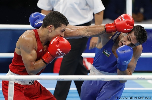 epa05487116 Mohammed Rabii of Morocco (red) and Shakhram Giyasov of Uzbekistan in action during the men's Welter (69kg) semi-final match of the Rio 2016 Olympic Games Boxing events at the Riocentro in Rio de Janeiro, Brazil, 15 August 2016.  EPA/VALDRIN XHEMAJ
