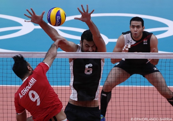 epa05480178 Adel Gholami (L) of Iran spikes the ball against Mamdouh Abdelrehim (C) of Egypt during the men's preliminary round match between Iran and Egypt for the Rio 2016 Olympic Games Volleyball tournament at Maracanazinho indoor arena in Rio de Janeiro, Brazil, 13 August 2016.  EPA/ORLANDO BARRIA