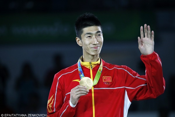 epa05495065 Gold medalist Zhao Shuai of China smiles on the podium for the men's -58kg competition of the Rio 2016 Olympic Games Taekwondo events at the Carioca Arena 3 in the Olympic Park in Rio de Janeiro, Brazil, 17 August 2016.  EPA/TATYANA ZENKOVICH